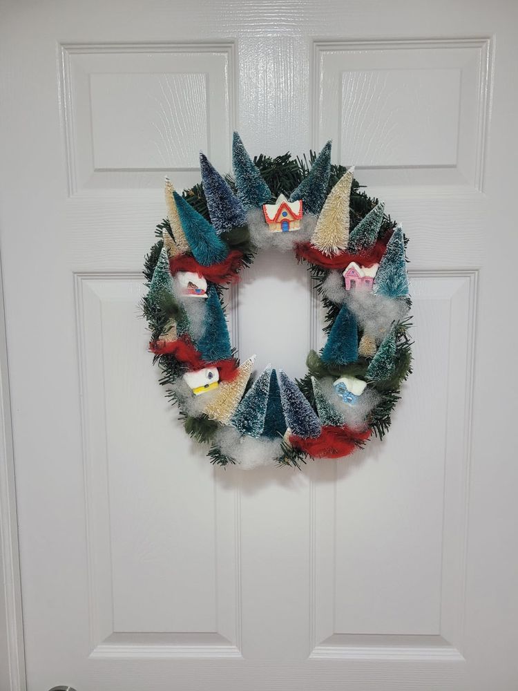 Playful pastel entryway decorated with bottle brush tree wreath surrounded by soft ambient lighting.