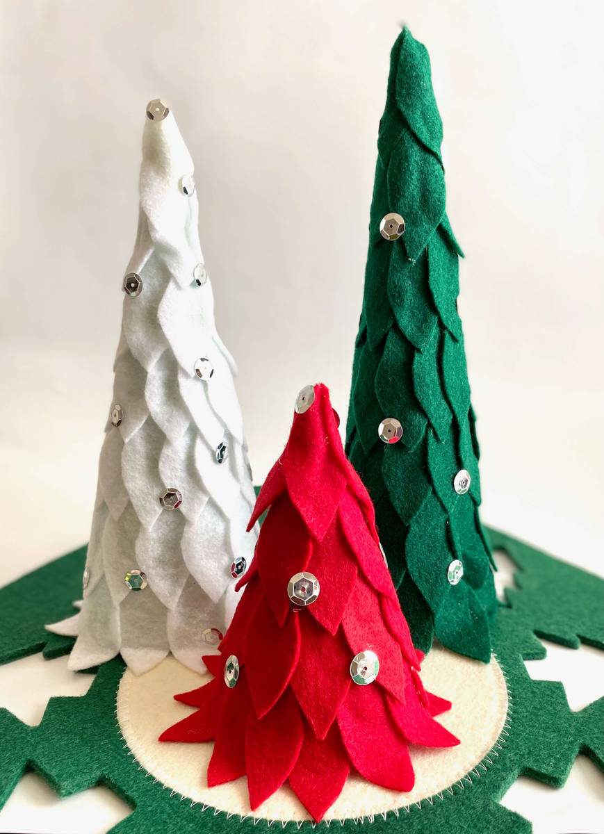 Kitchen floating shelf decorated with felt christmas trees, ceramic mugs, wooden boards, soft lighting