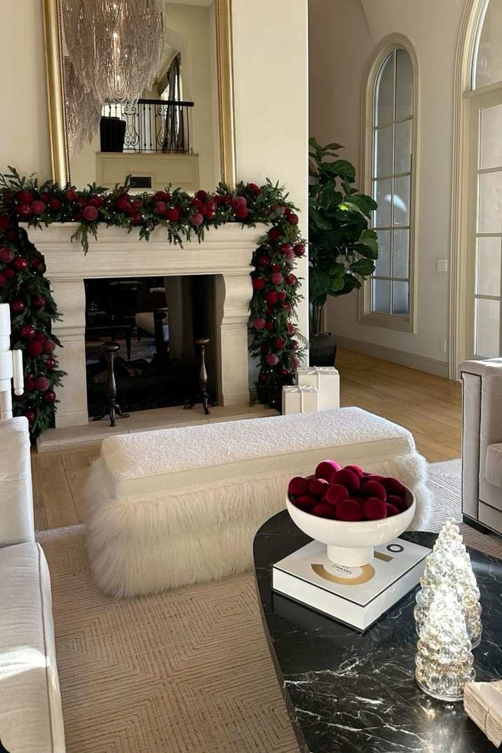 Stack of burgundy and cream wool blankets on a wooden bench near the fireplace