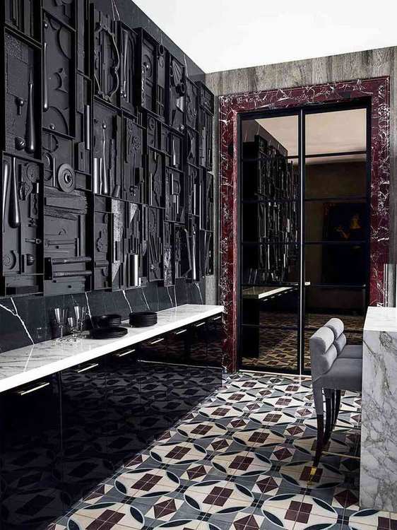 A butler’s pantry featuring a striking black and white geometric tiled floor and dark cabinetry.