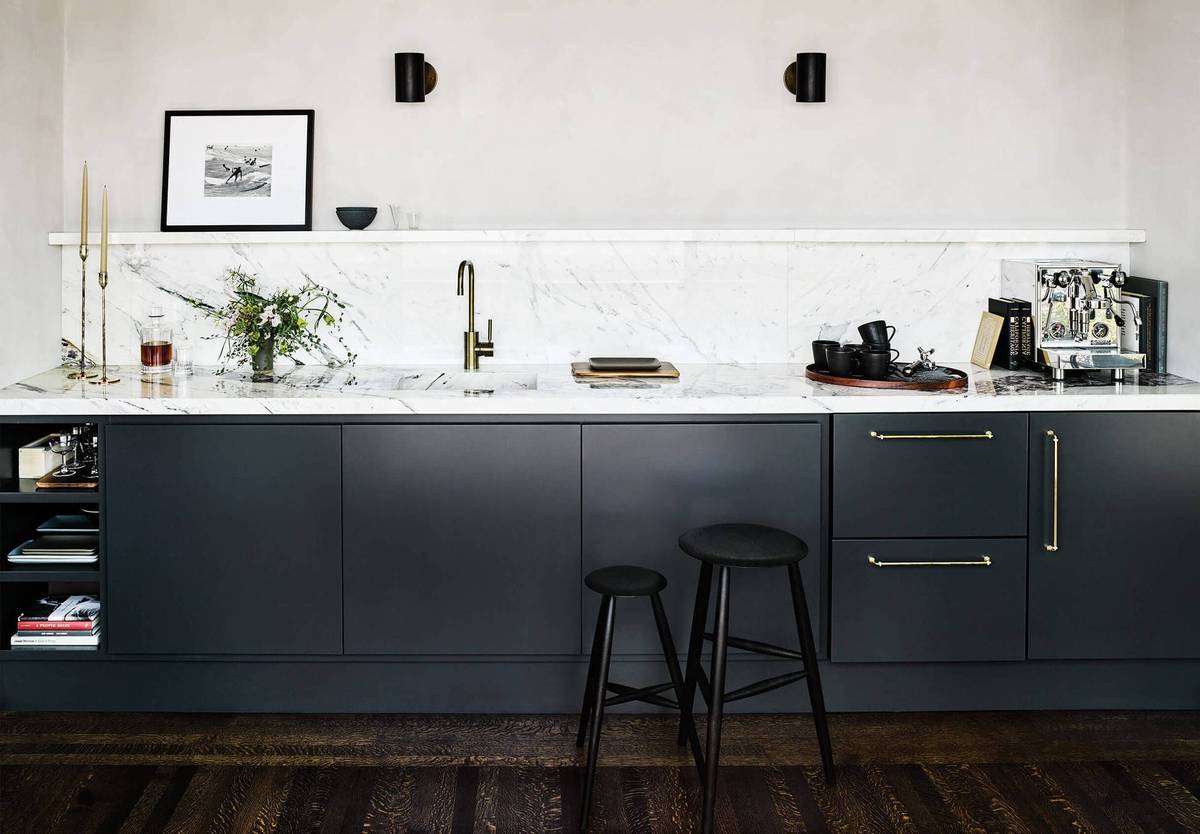 A sleek butler’s pantry designed as a cocktail bar with navy cabinets and recessed lighting.