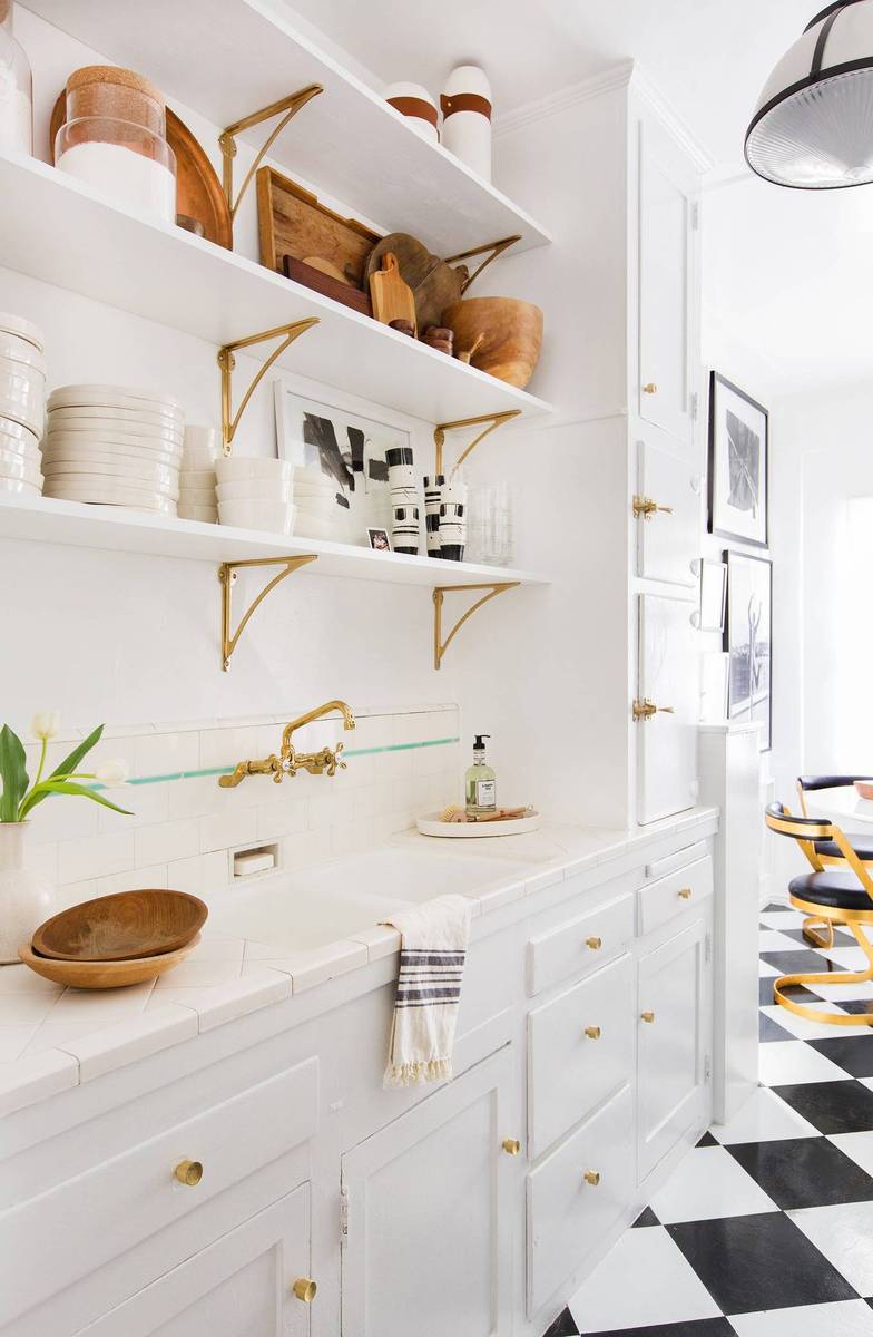 Bright white butler's pantry featuring a striking black and white checkered tile floor layout.