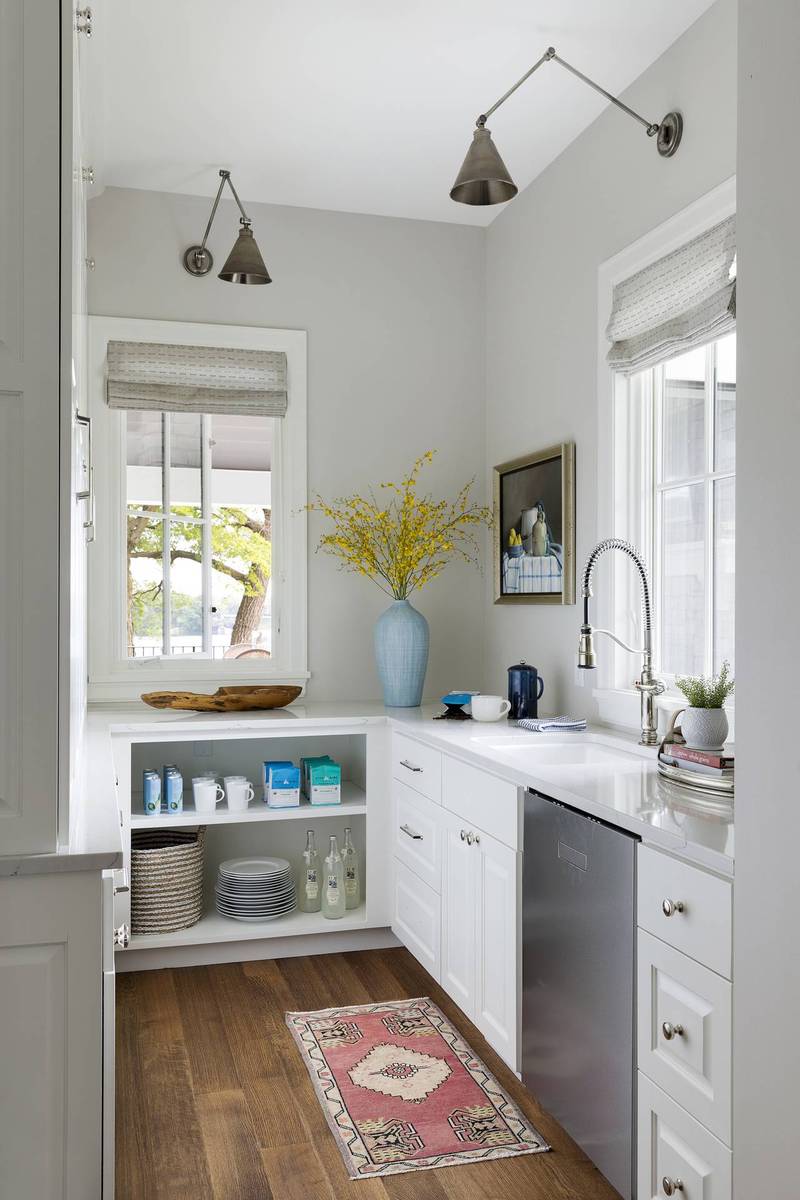 Clean white butler's pantry featuring a large apron-front farmhouse sink and chrome gooseneck faucet.
