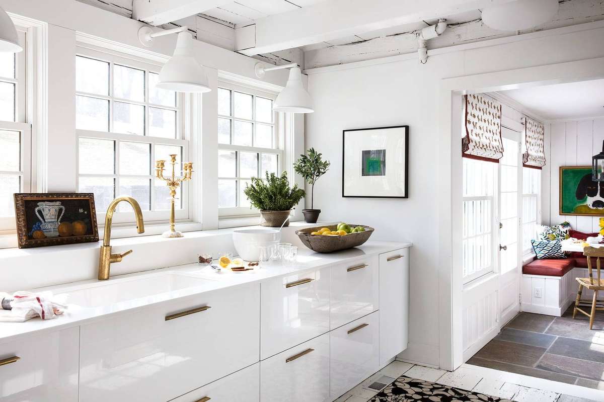 Elegant white butler's pantry featuring a stunning brushed gold gooseneck faucet and quartz counters.
