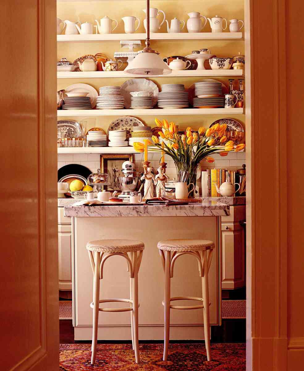 Modern butler's pantry styled with floating natural oak wood open shelves against a white subway tile wall.