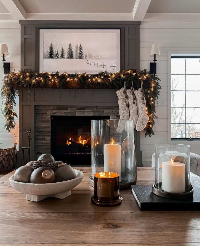 Small metal lanterns with tea lights on a coffee table near a stone fireplace.