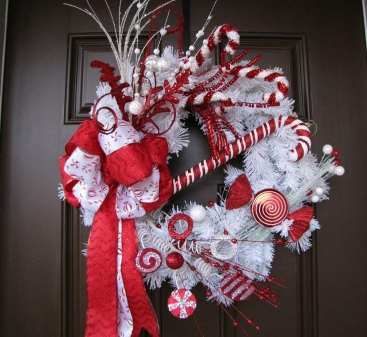Vibrant holiday front door featuring red and white candy cane striped wreath with glitter accents.