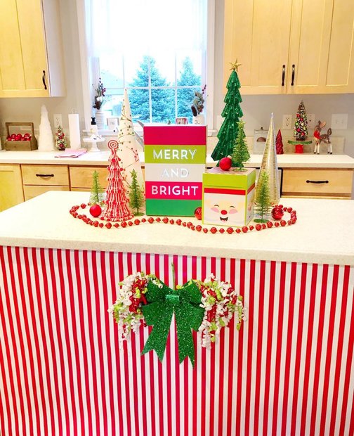 Kitchen island wrapped in red and white candy stripe fabric with a bow.