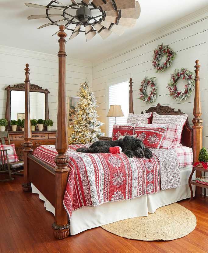 Canopy bed with hanging green wreaths, pet bed, soft linens, and warm family-friendly lighting.