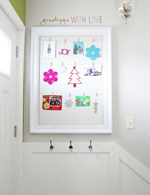 Contemporary entryway featuring vertical oak slats holding greeting cards in soft diffused warm light.