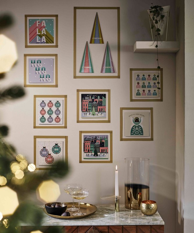 Minimalist home office with cream walls featuring greeting cards taped in clean grid with washi tape.