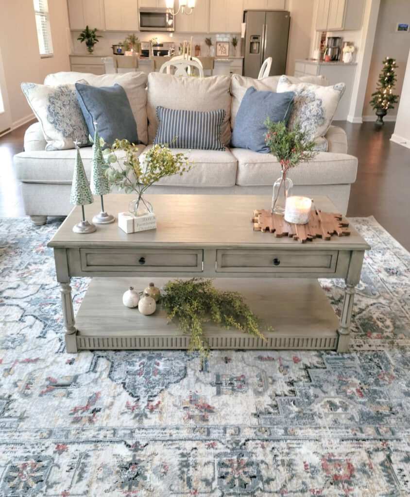 White ceramic mini trees and a small bud vase on a light wood coffee table.