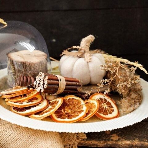 Kitchen or dining area with dried orange garlands, wooden bowls, rustic aesthetic, natural lighting.