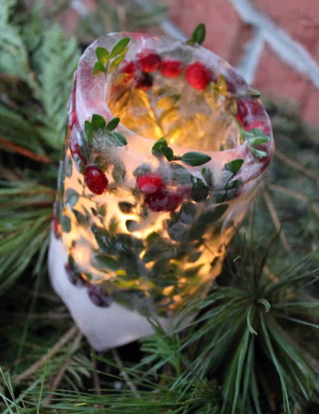 Outdoor patio or porch with frozen ice lanterns, glowing candles, winter garden setting.