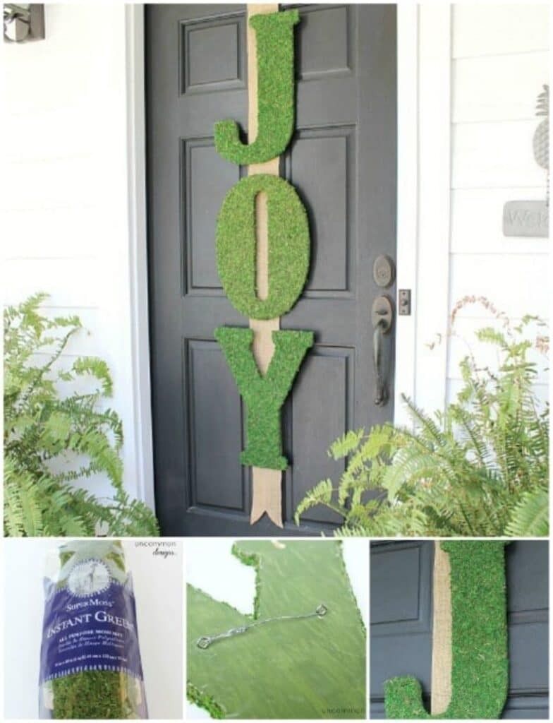 A festive front door featuring a moss-covered JOY sign with organic woodland holiday decor.