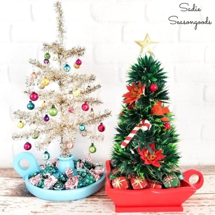 Small decorative bottle brush trees planted inside vintage porcelain teacups.