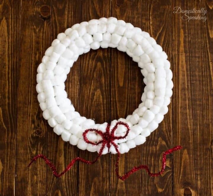 A wreath made of white painted wooden beads arranged in a circle.