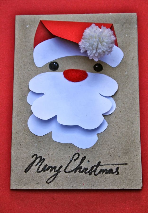 Antique brass picture frames filled with artistically arranged Christmas cards on a dark moody mantle.