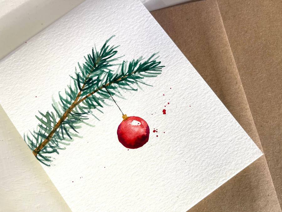 A distressed white wood frame with chicken wire mesh holding colorful holiday cards.