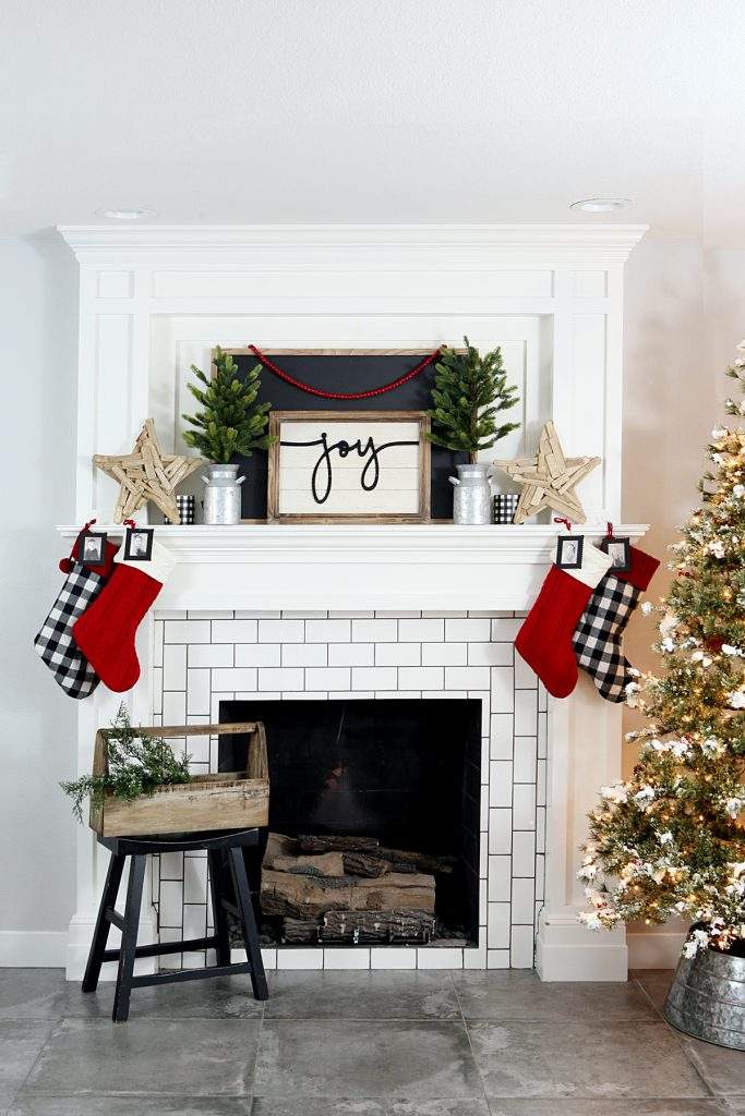 Front porch with metal lanterns, cedar garland, black front door, minimalist holiday decor, outdoor lighting.