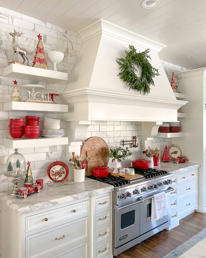 Kitchen island with a three-tier tray, miniature trees, pinecones, cinnamon sticks, neutral kitchen decor.