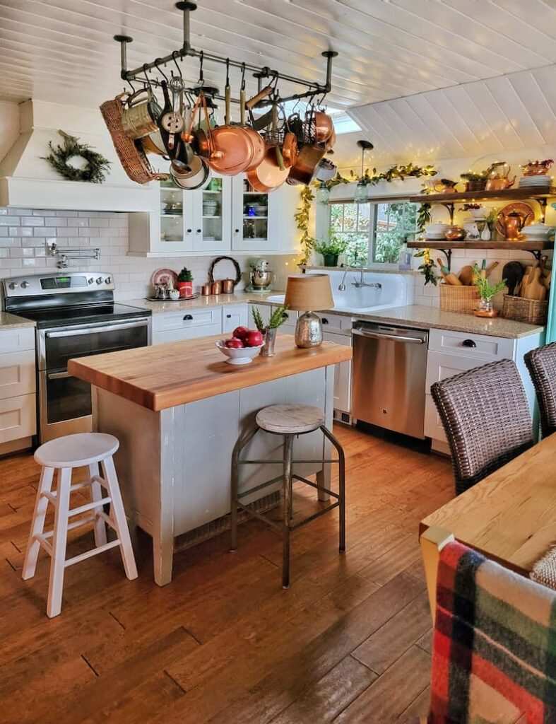 Kitchen coffee bar with festive mugs, peppermint sticks, warm lighting, wooden signage, seasonal decor.