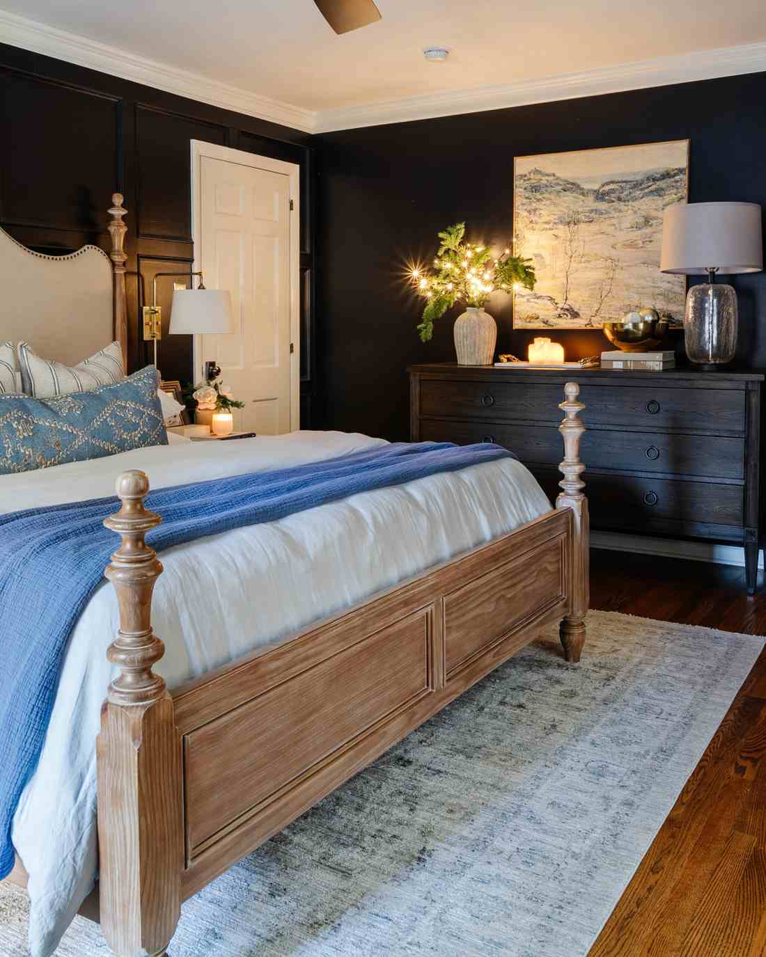 Mudroom with hooks, winter coats, pine wreaths on hooks, wooden bench, organized seasonal storage.
