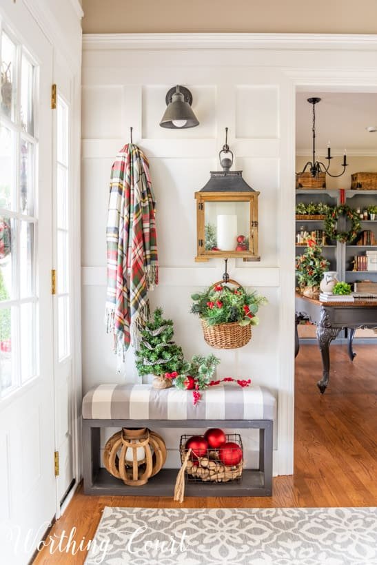 Small bathroom with eucalyptus sprig, scented candle, linen towels, neutral holiday accents.