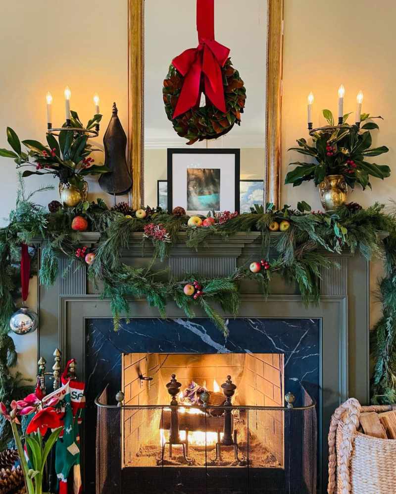 A clean Scandinavian entryway featuring a simple wreath, wooden bench, and neutral Christmas decor.