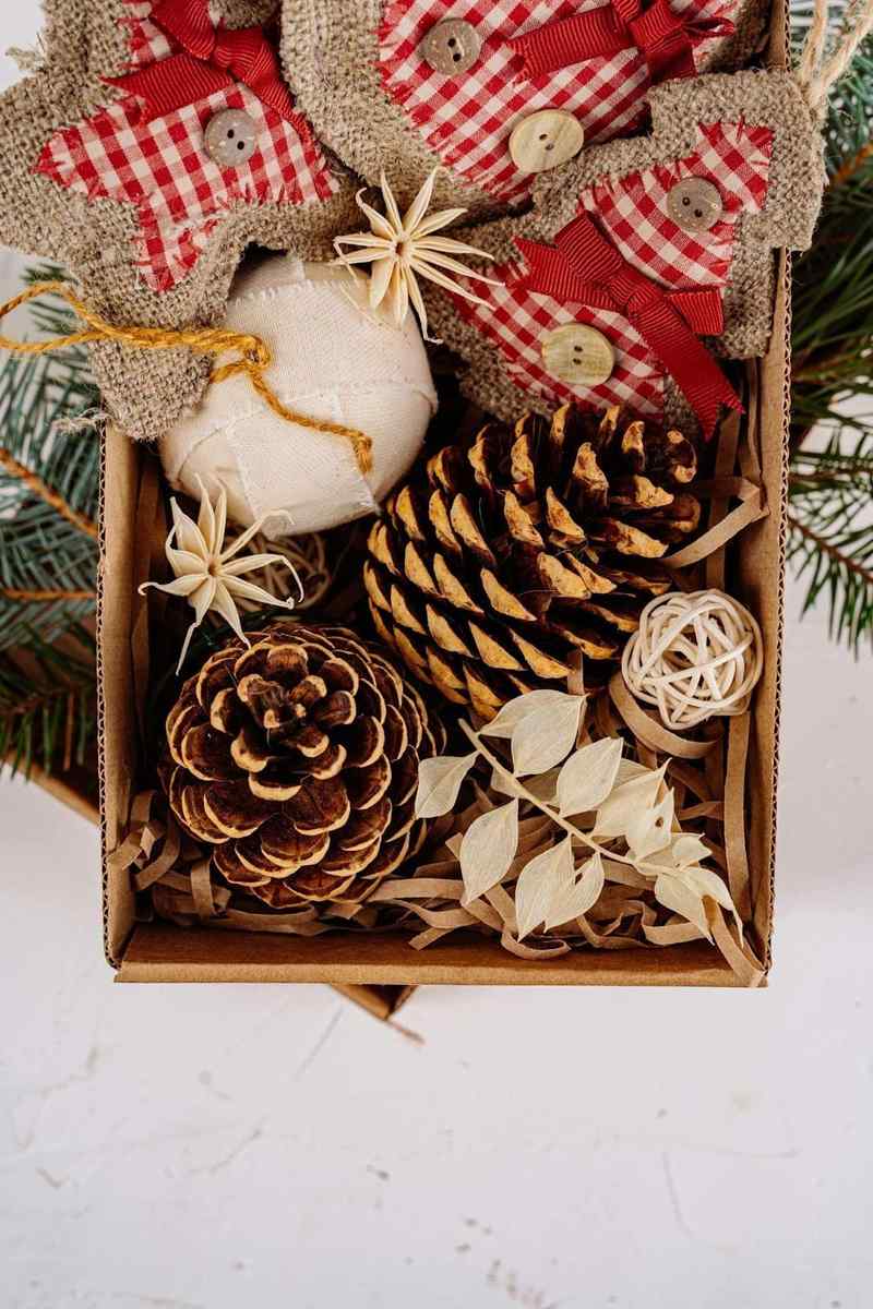 A kitchen counter with vintage cookie jars, ceramic houses, and a wreath hanging in the window.