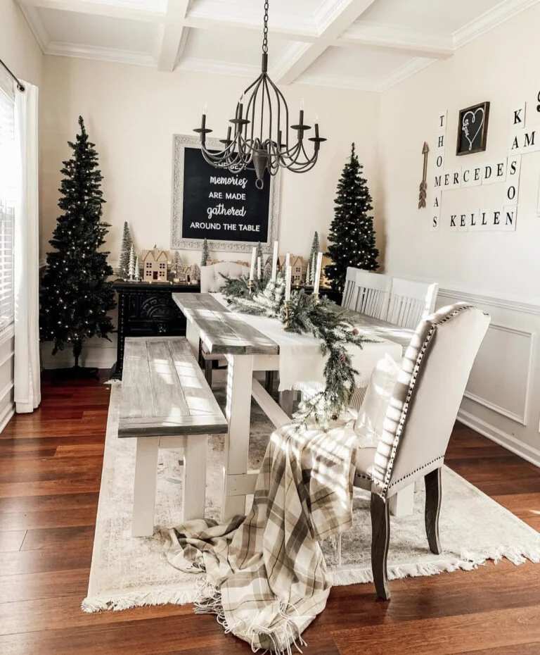 Dining table with large Merry Christmas sign and sprawling pine branches.