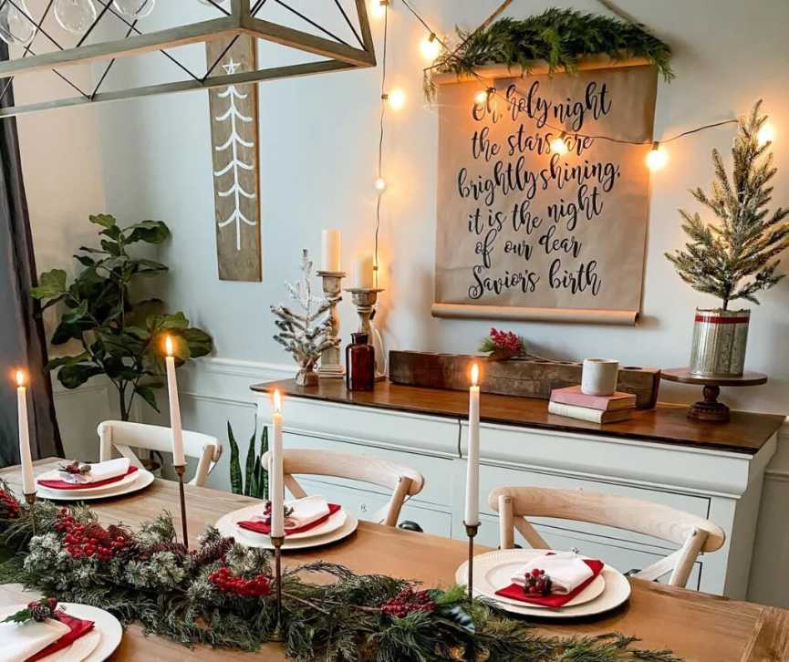 Dining table with red linen napkins and a Holy Night scroll sign.