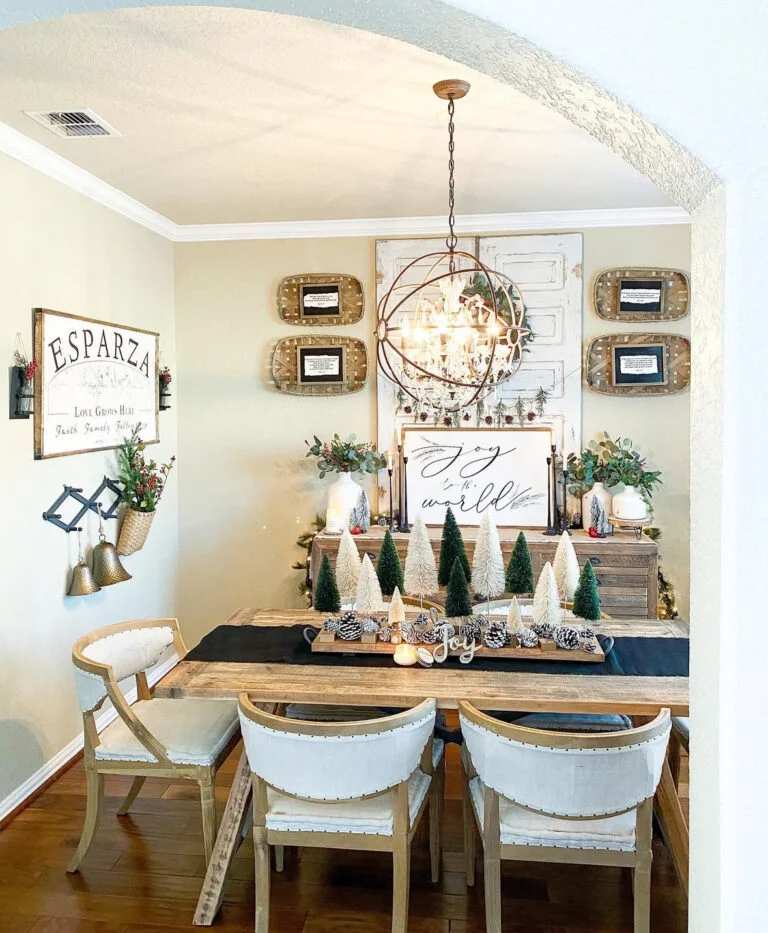 Dining table with silver bottle brush trees and a Joy to the World sign.