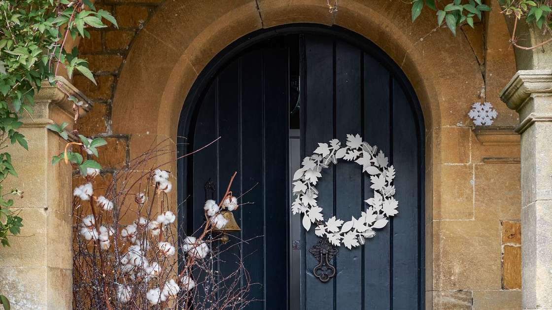 Simple christmas front door decorating ideas with large red berry wreaths and lanterns.