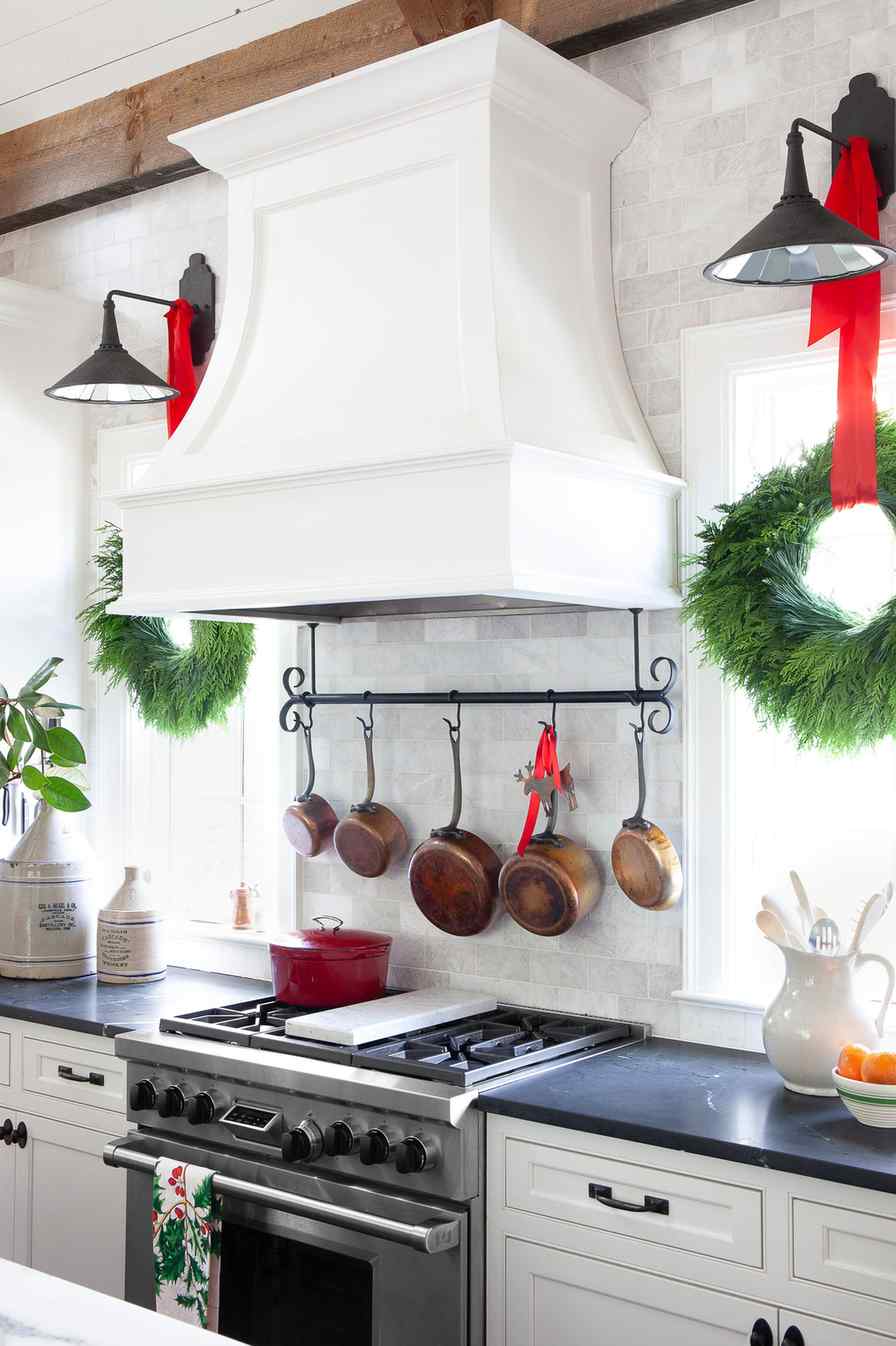 Kitchen with reclaimed barn wood cabinets, pine cone clusters, natural oil finish, warm ambient lighting, rustic holiday charm