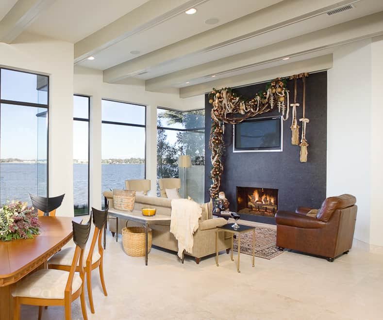 Country living room with TV above reclaimed wood mantel, burlap garland, plaid pillows, amber lantern lighting.