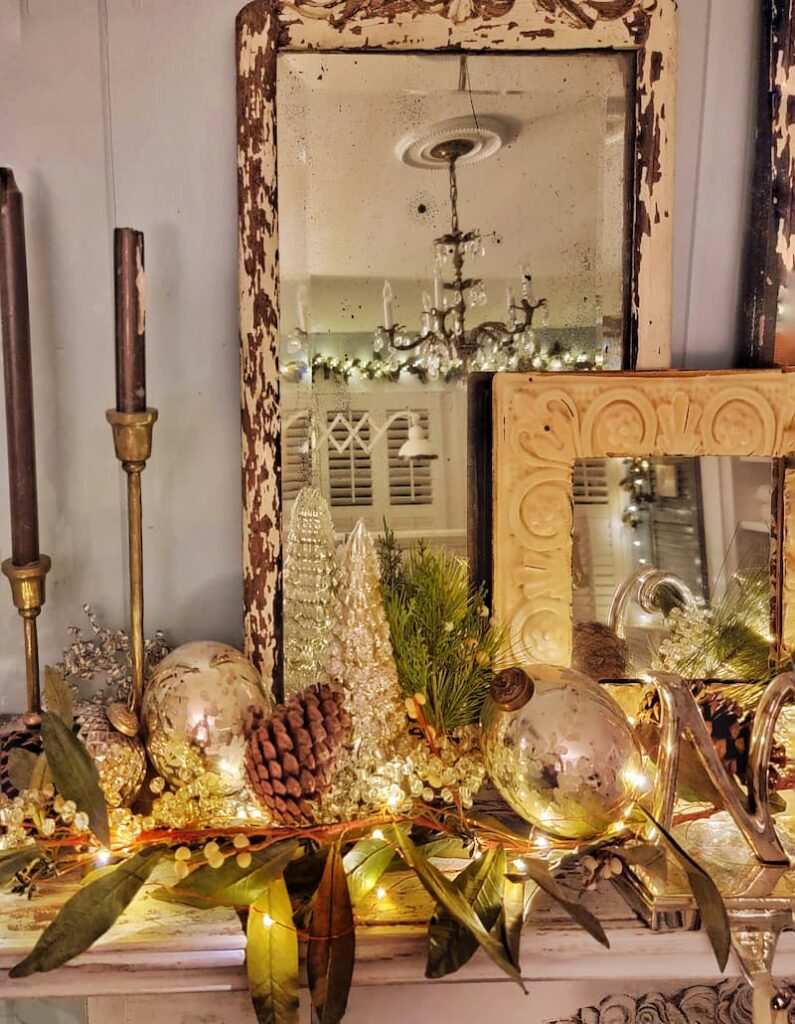Living room sideboard holding three glass cloches filled with velvet baubles and micro LED lights on wooden bases.