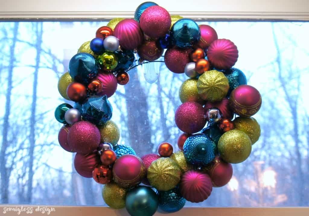 Aqua blue and pearl white christmas ornament wreath on a weathered grey shiplap door.