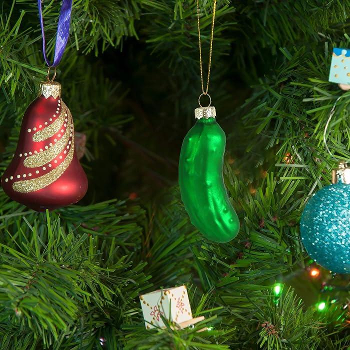 A large, snowy Christmas wreath with a glass pickle ornament hidden inside the foliage.