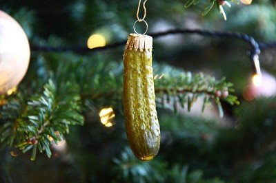 A festive farmhouse kitchen counter with holiday decor and a small pickle ornament.