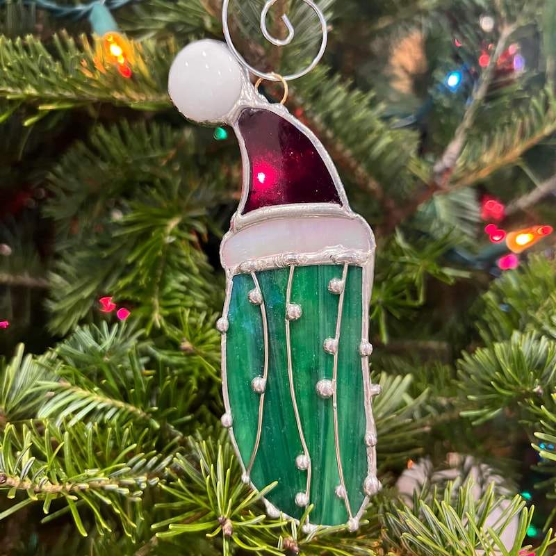 A tree decorated entirely in shades of green with a pickle ornament as the highlight.