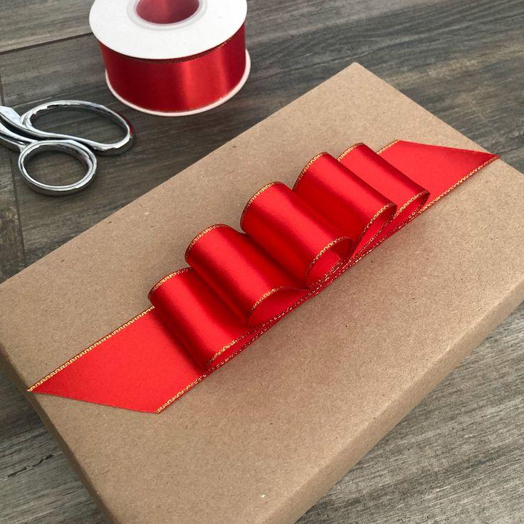 Bright white kitchen cabinets with boxwood wreaths on crimson satin ribbon, warm task lighting.