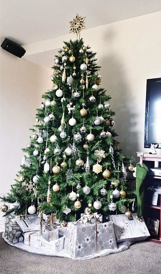 Minimalist living room, classic green Christmas tree, silver and gold baubles, clean lines