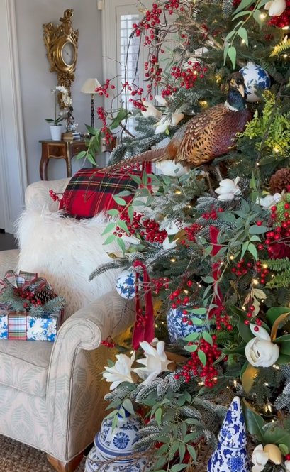 Christmas tree adorned with hand‑painted pheasant ornaments, brass star topper, soft white lights.
