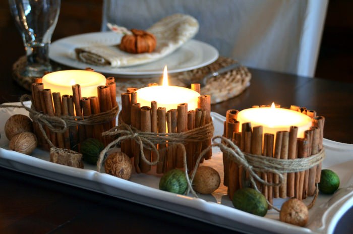 Coffee table, three cinnamon stick candles, slate tray, woven blanket, soft warm lighting