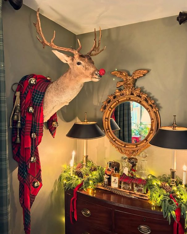Formal living room mantel with fresh pine garland, gold baubles, soft white candles, polished brass.
