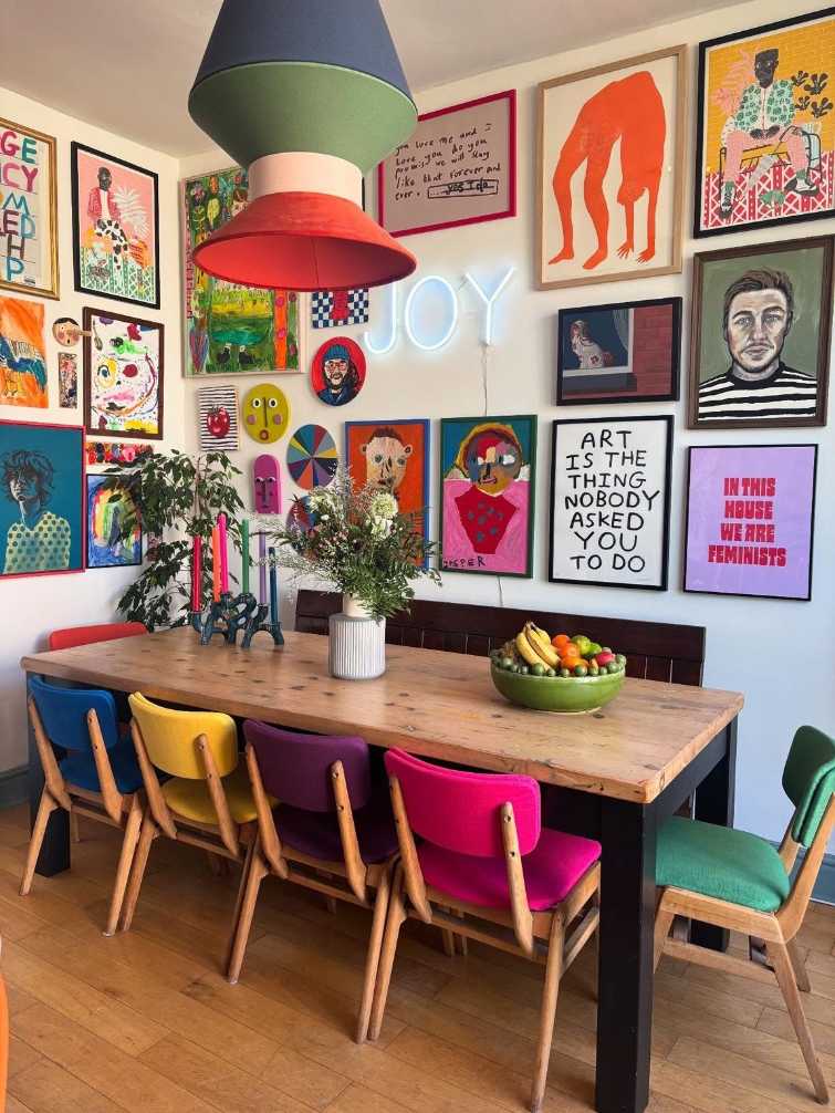 Dining table with four mismatched colorful chairs in different styles and colors.