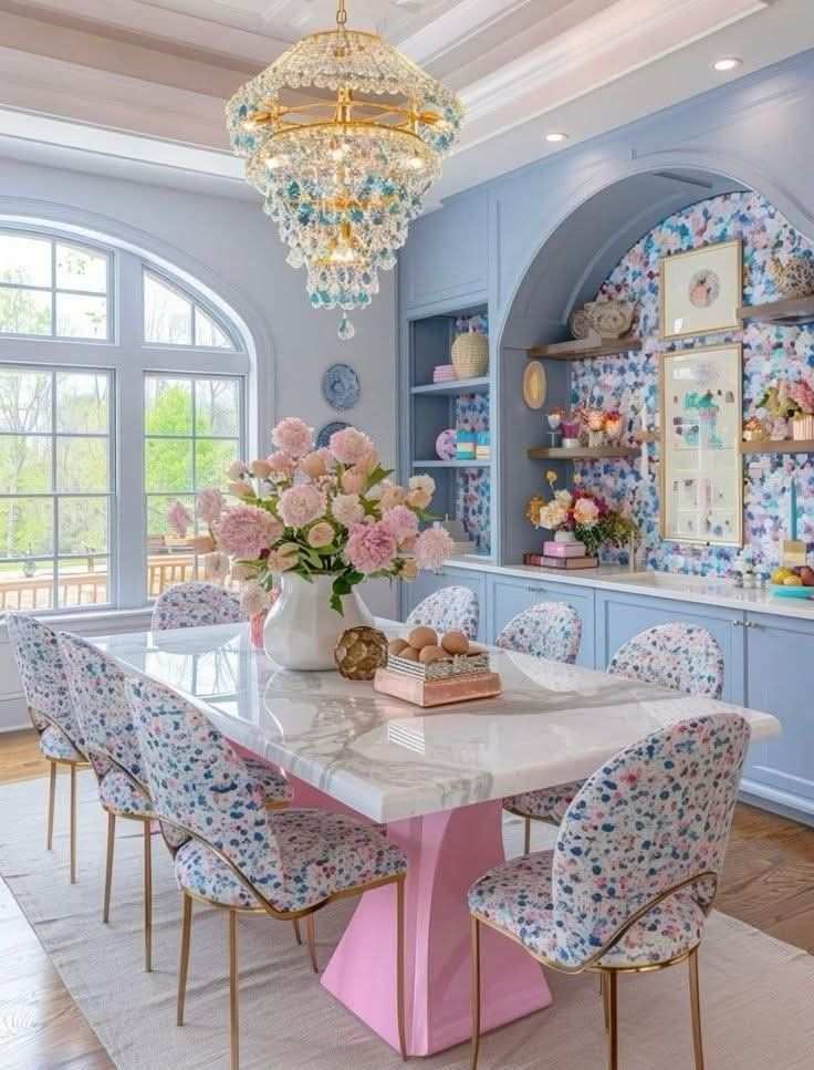 Dining room with pastel walls, a wooden table, and colorful chairs.