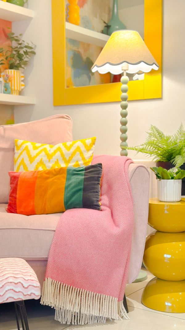 Sofa with a mix of rainbow colored cushions and a neutral background.