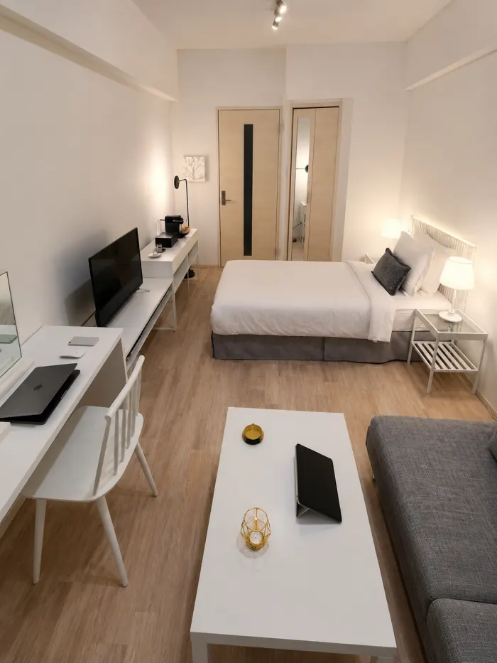 Small studio bedroom layout featuring distinct sleeping, work, and lounge zones using modular furniture.